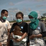 Adorable baby orangutan gives rescuers thumbs up as she's freed from captivity